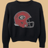 Black sweater with a red football helmet graphic on a white background