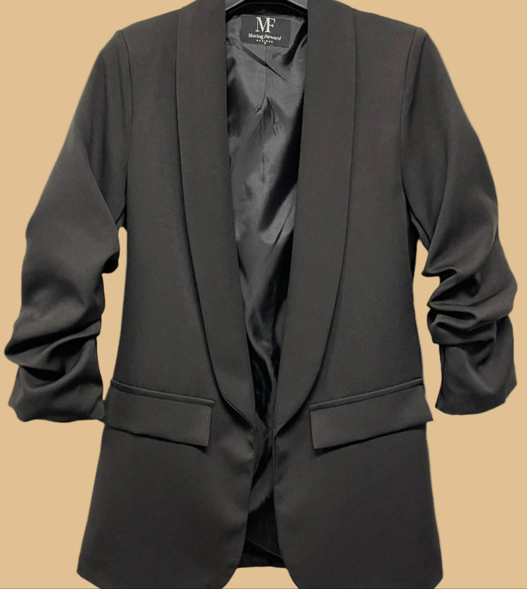 Black blazer on a hanger with a visible brand label against a white background