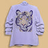 Light purple shirt with a tiger design on a rack against a dark background