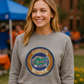 Woman wearing a gray sweater with a Florida Gators logo outdoors.