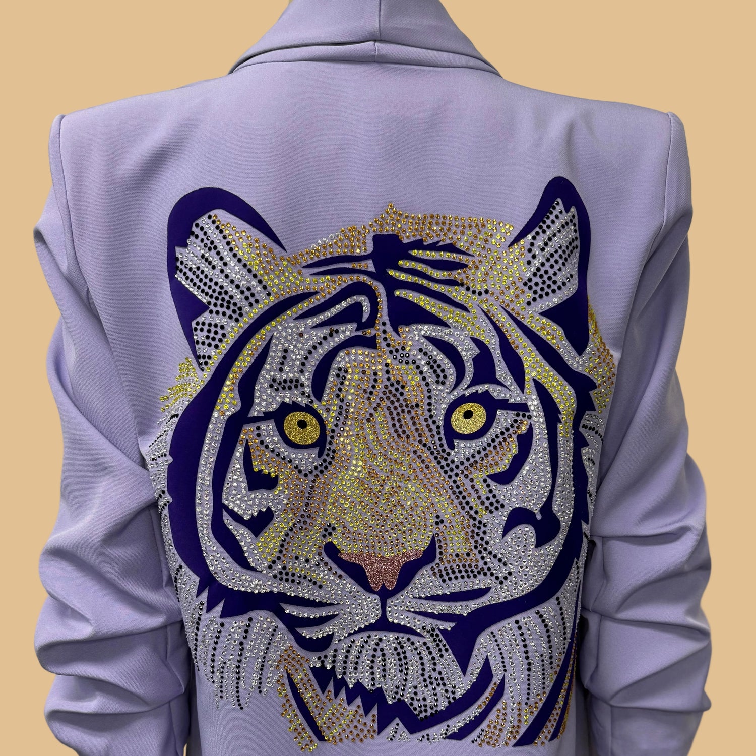 Light purple jacket with a tiger face design on the back against a beige background