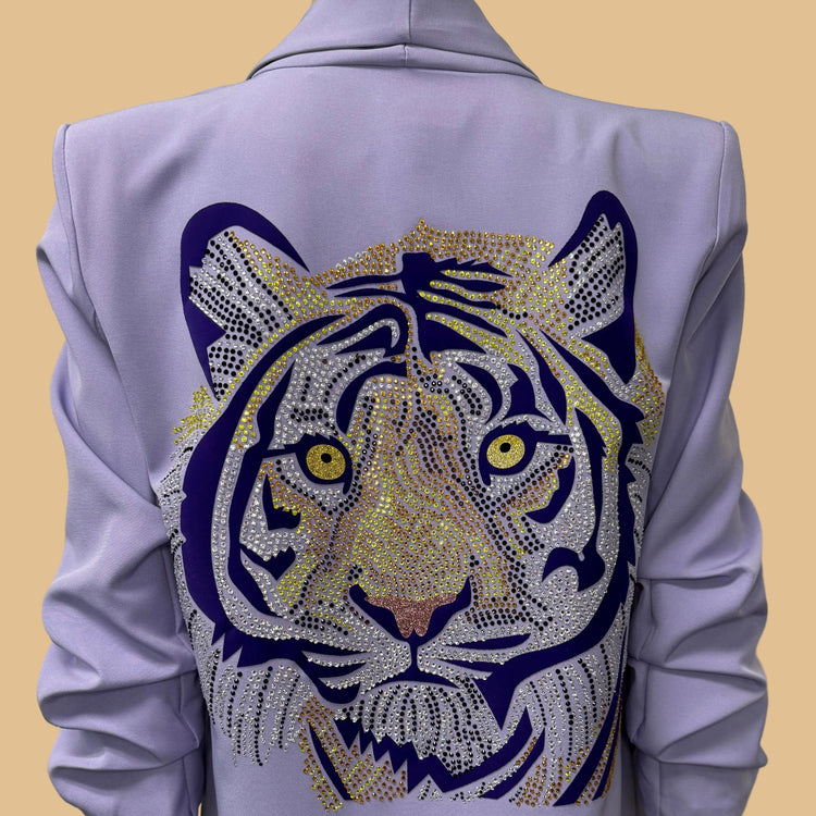 Light purple jacket with a tiger face design on the back against a beige background