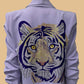 Light purple jacket with a tiger face design on the back against a beige background