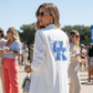 Woman wearing a white jacket with &