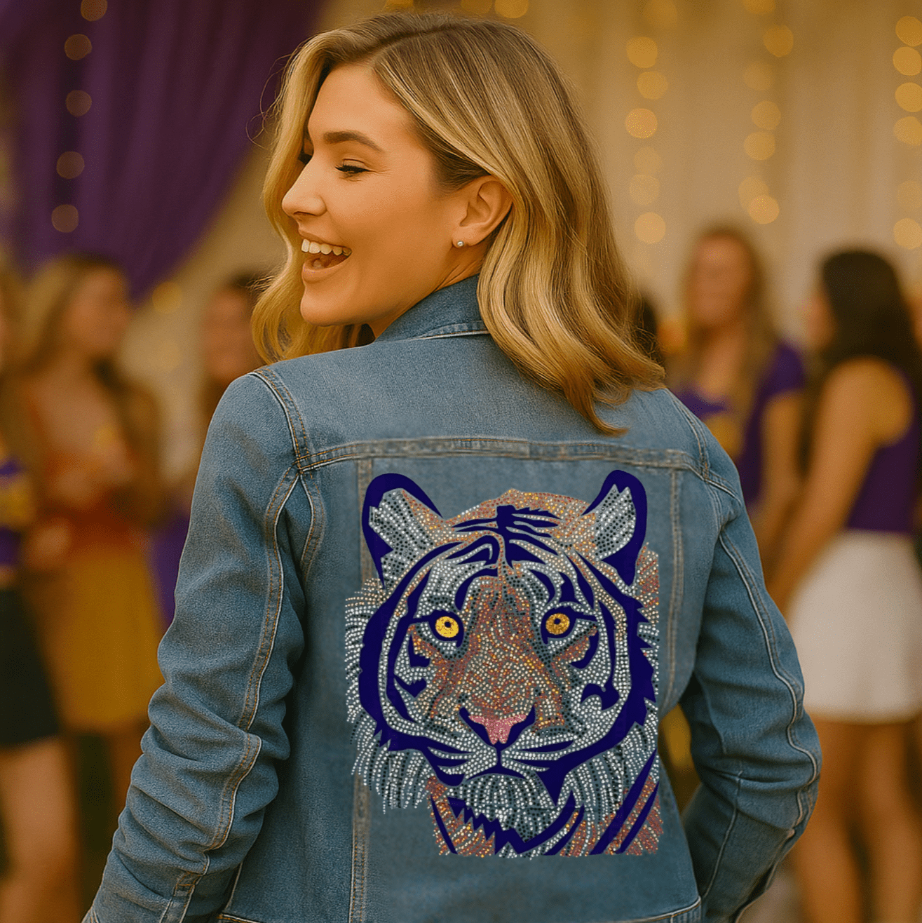 Woman wearing a denim jacket with a tiger design at a party.