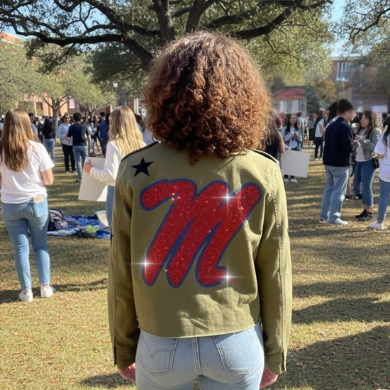 Person wearing a green jacket with a large red &