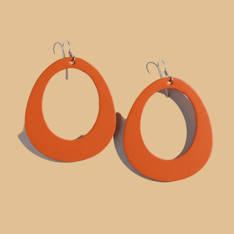 Pair of earrings with orange and gray circular design on a white background