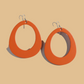 Pair of earrings with orange and gray circular design on a white background