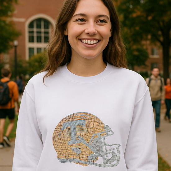 Woman wearing a white sweatshirt with a helmet design on a college campus