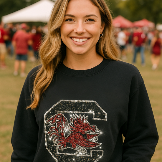 Woman wearing a black sweatshirt with a red and white logo in an outdoor setting