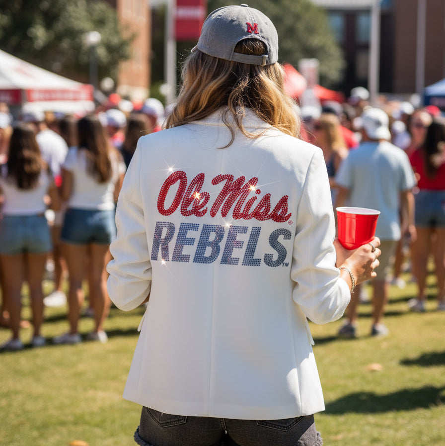 Person wearing an ' Ole Miss Rebels ' jacket at a sports event.