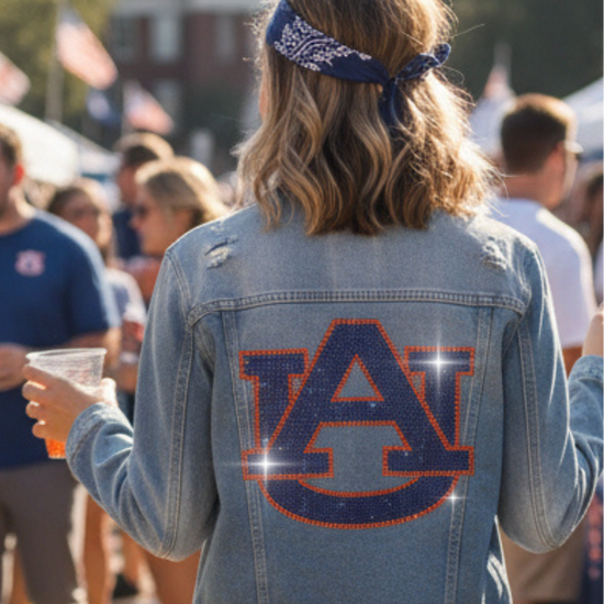 Person wearing an Auburn University denim jacket at a casual outdoor event.