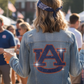 Person wearing an Auburn University denim jacket at a casual outdoor event.