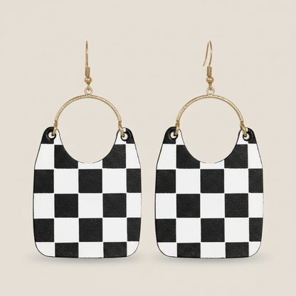 Black and white checkered earrings with gold hoop accents on a beige background