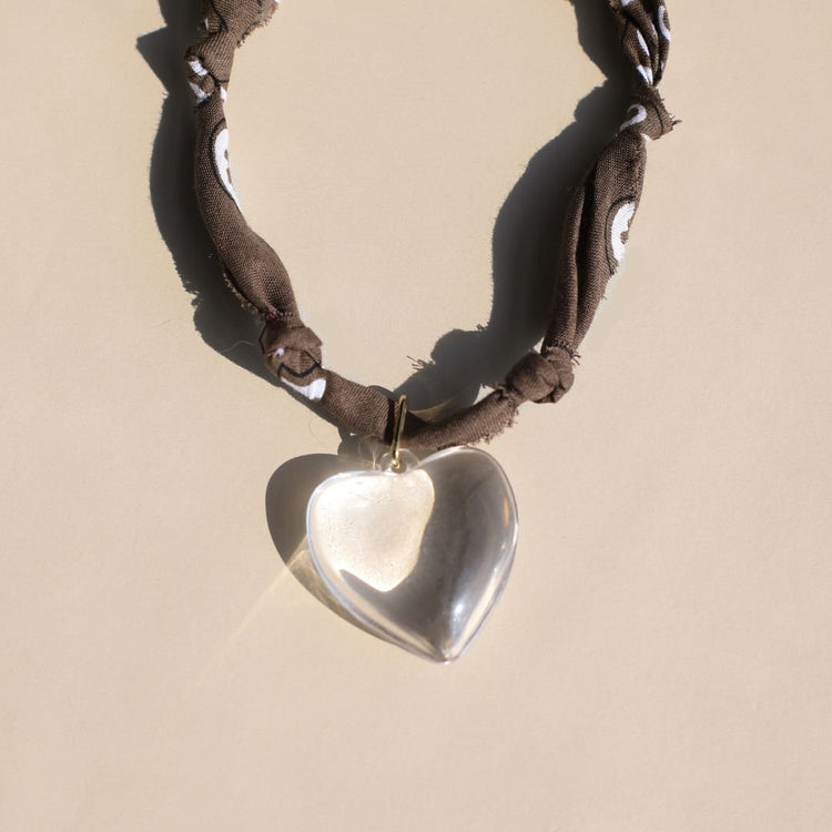 Necklace with a heart-shaped pendant on a beige background