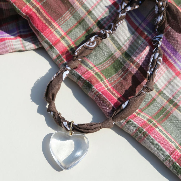 Plaid fabric with a heart-shaped object on a light background