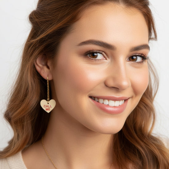 Close-up of a woman wearing earrings with heart-shaped pendants.
