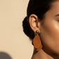 Pair of brown layered earrings on a beige background