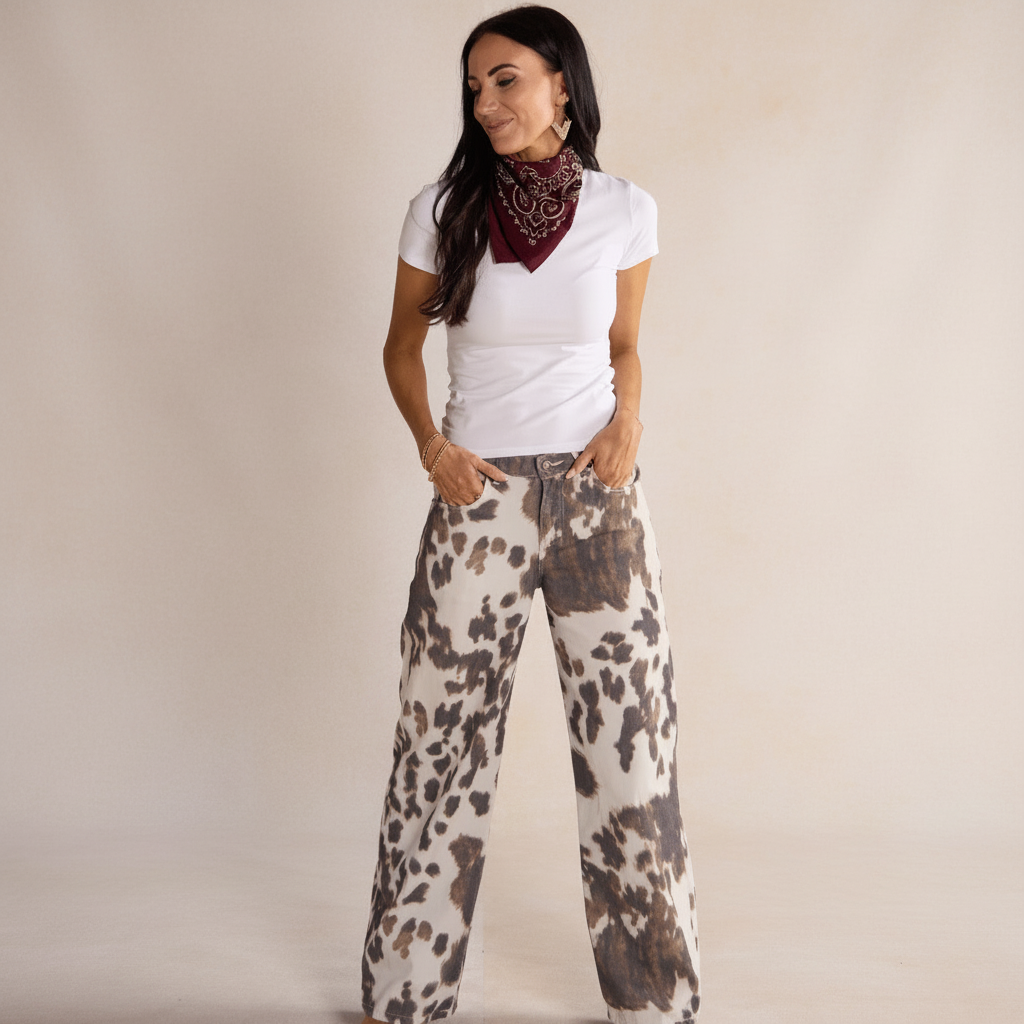 Woman wearing a white t-shirt and patterned pants against a beige background