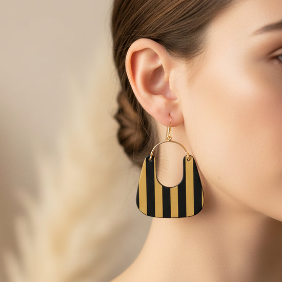 Black and gold striped earrings on a light gray background