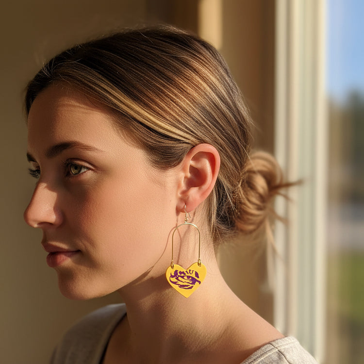 Heart-shaped earrings with a purple logo on a beige background