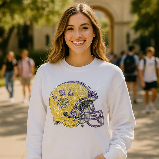 Woman wearing a white sweatshirt with LSU logo in an outdoor setting
