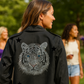 Woman wearing a black jacket with a tiger design outdoors
