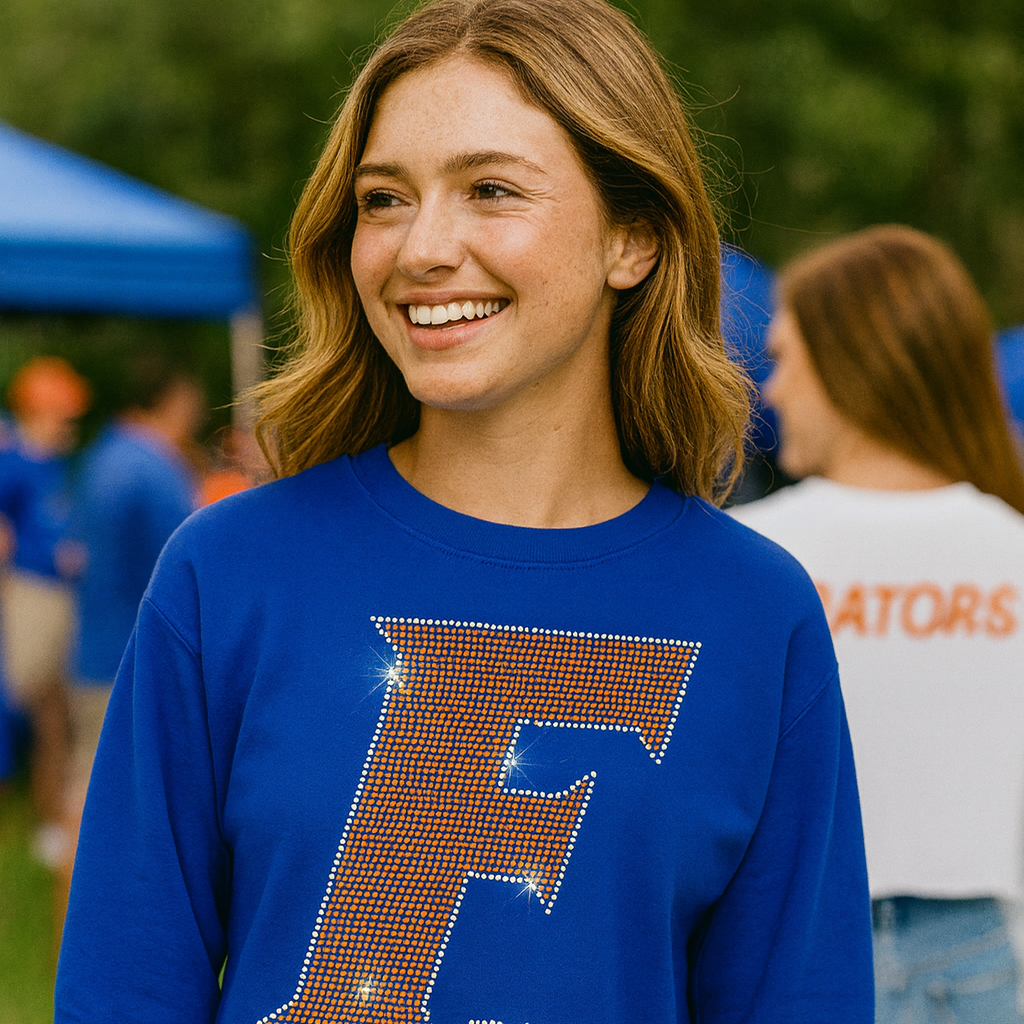 Woman wearing a blue sweatshirt with a large &