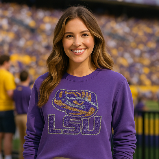 Woman wearing a purple LSU sweatshirt in a stadium setting