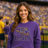 Woman wearing a purple LSU sweatshirt in a stadium setting