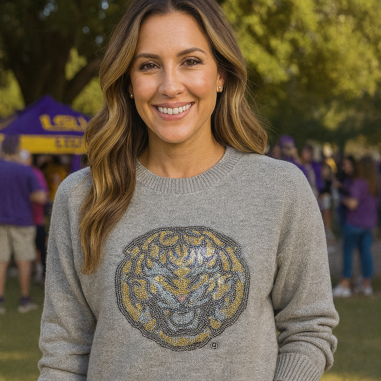 Woman wearing a gray sweater with a tiger logo outdoors