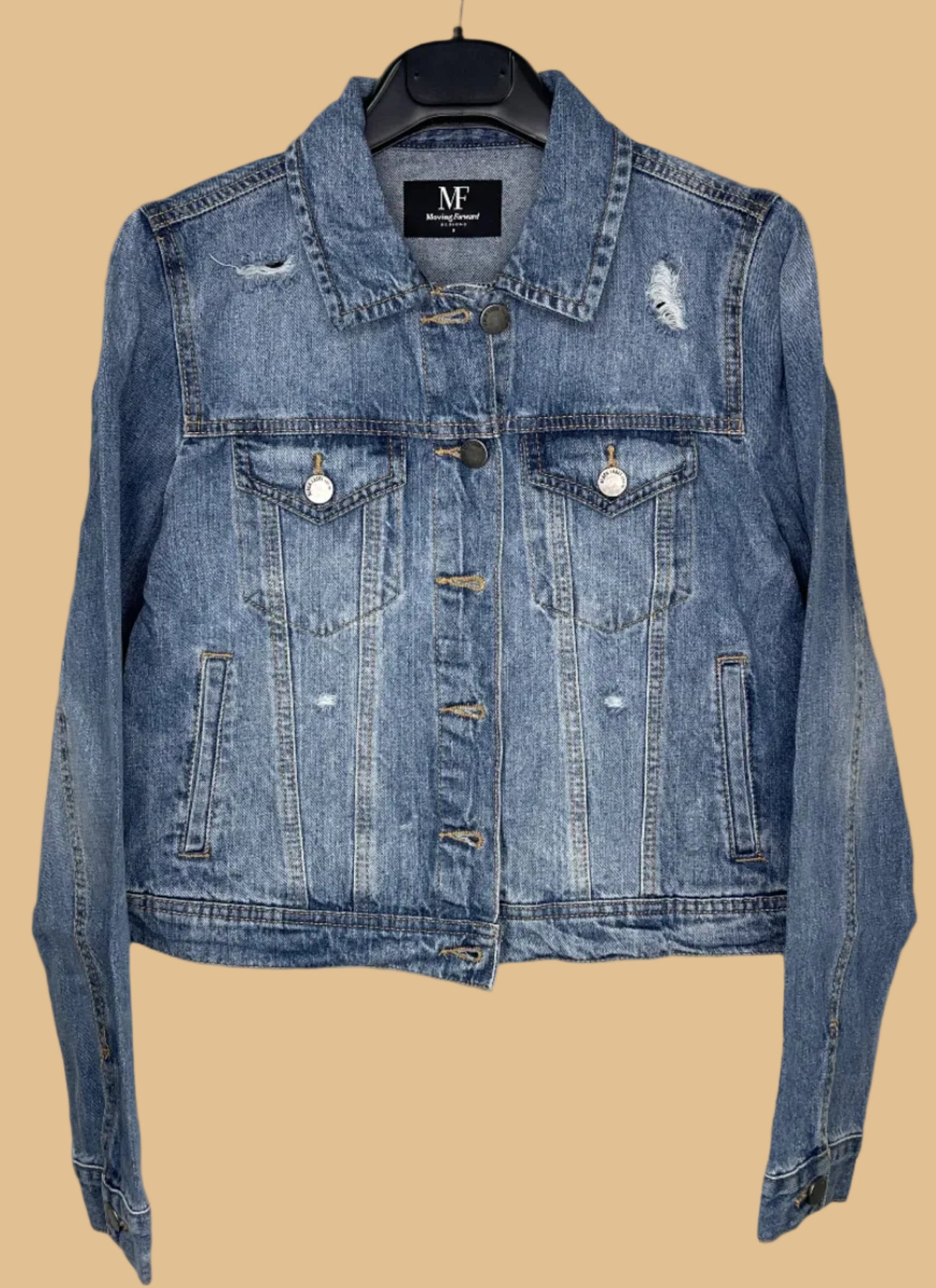 Blue denim jacket on a hanger with a visible brand label against a white background