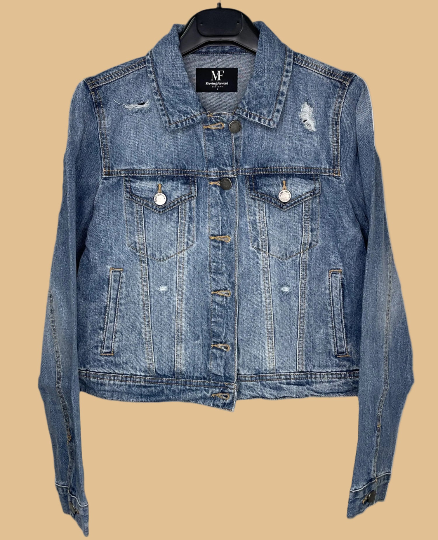 Blue denim jacket on a hanger with a visible brand label against a white background