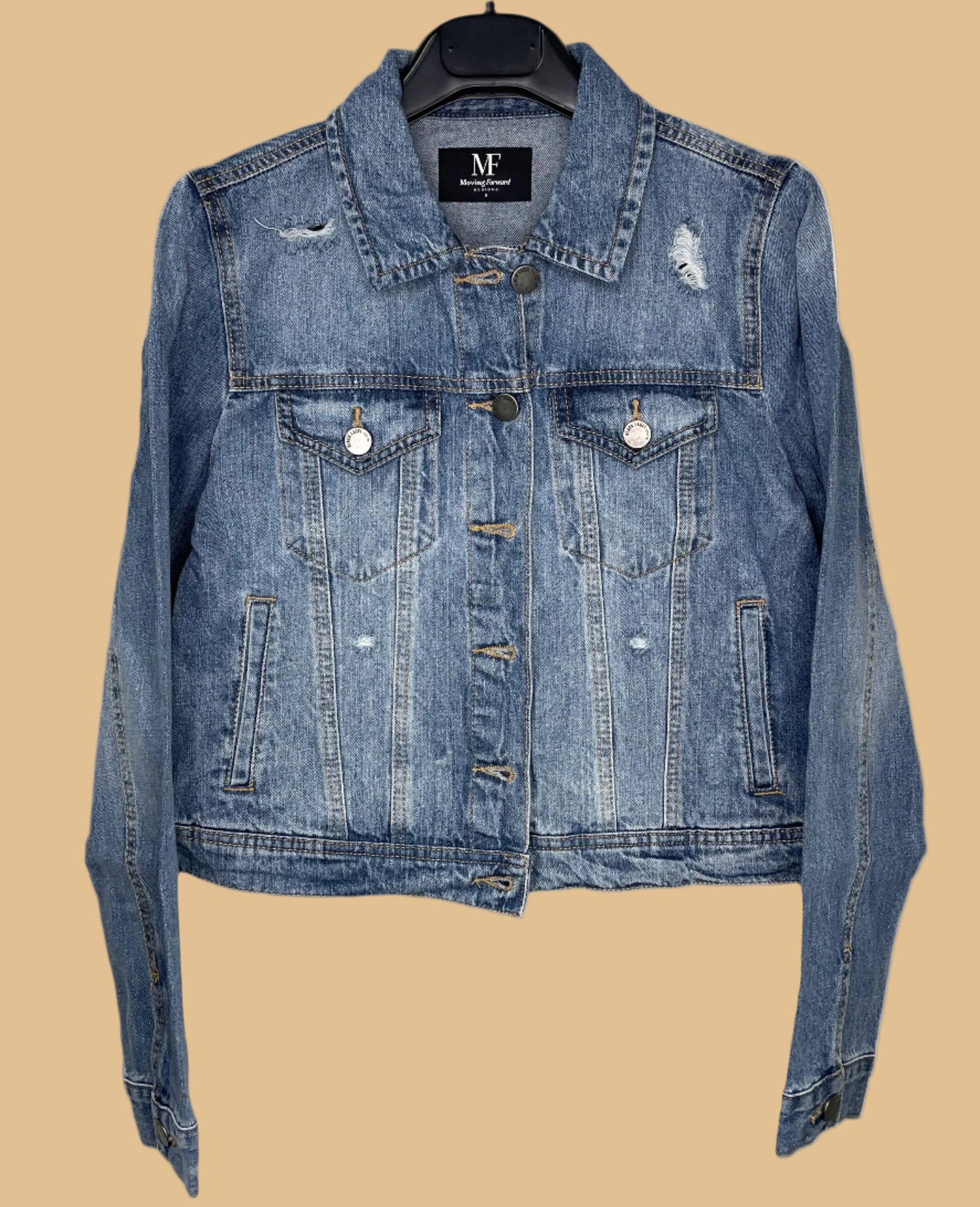 Blue denim jacket on a hanger with a visible brand label against a white background