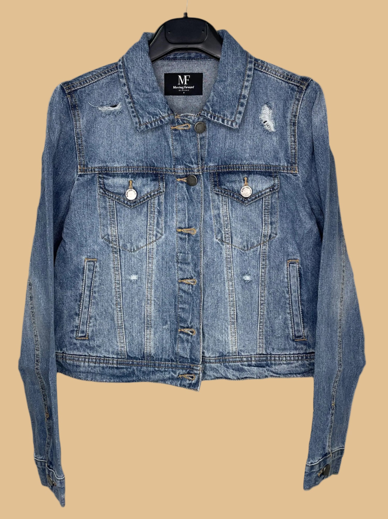 Blue denim jacket on a hanger with a visible brand label against a white background