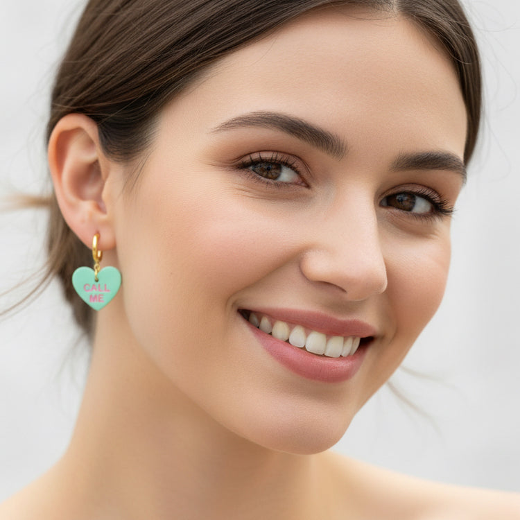 Close-up of a woman wearing a heart-shaped earring with &