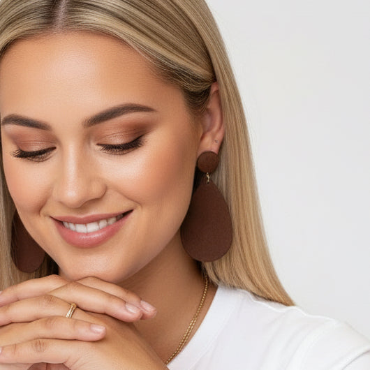 Woman wearing large brown earrings against a white background