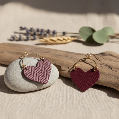 Heart-shaped earrings with gold hooks on a beige background