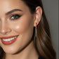 Close-up of a woman wearing red earrings with a blurred background