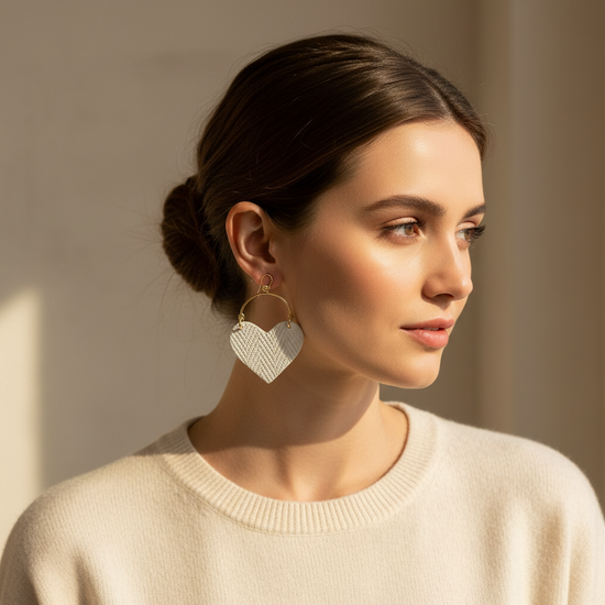 Heart-shaped earrings with gold hooks on a beige background