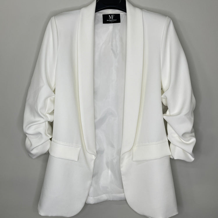 White blazer on a hanger against a gray background