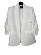 White blazer on a hanger with a visible brand label against a white background