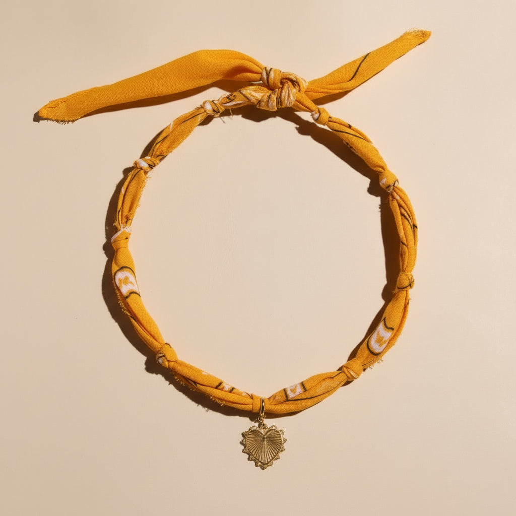 Yellow headband with a decorative pendant on a beige background
