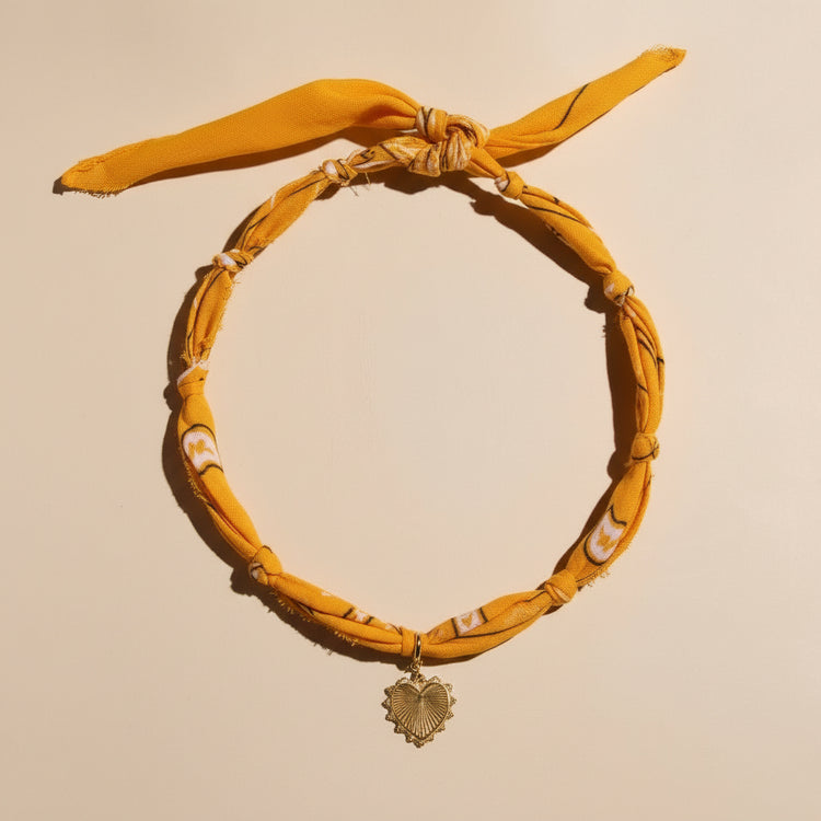 Yellow headband with a decorative pendant on a beige background