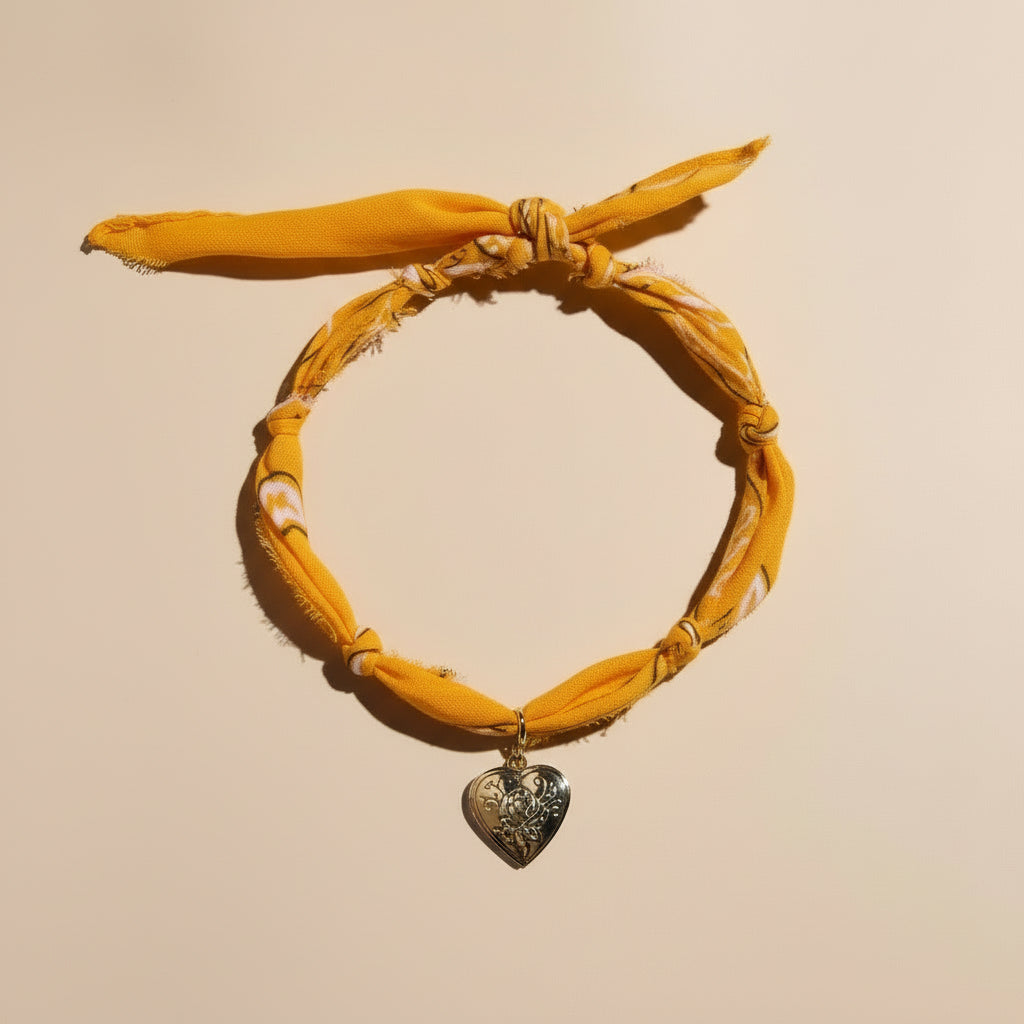 Yellow headband with a heart-shaped pendant on a beige background