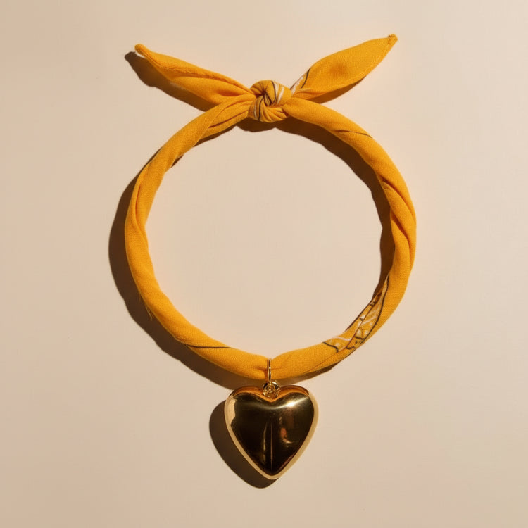 Yellow headscarf with a heart-shaped pendant on a beige background