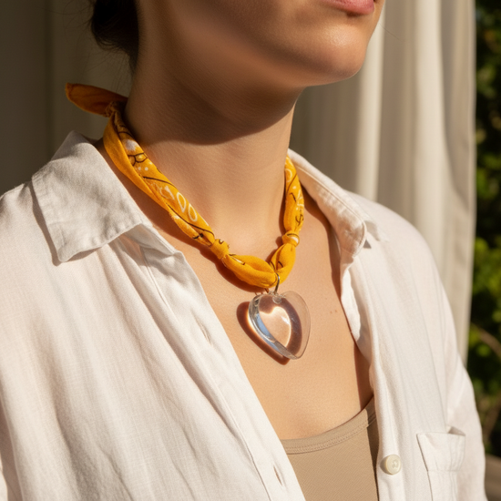 Yellow headband with a heart-shaped pendant on a beige background