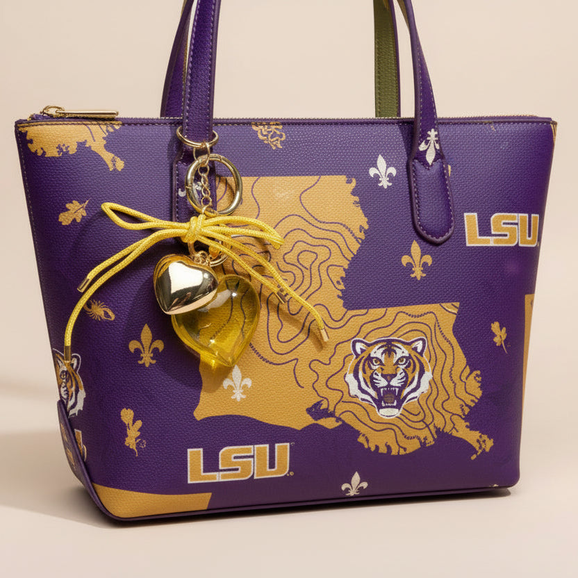 Heart-shaped keychain with yellow heart charm and gold accents on a beige background